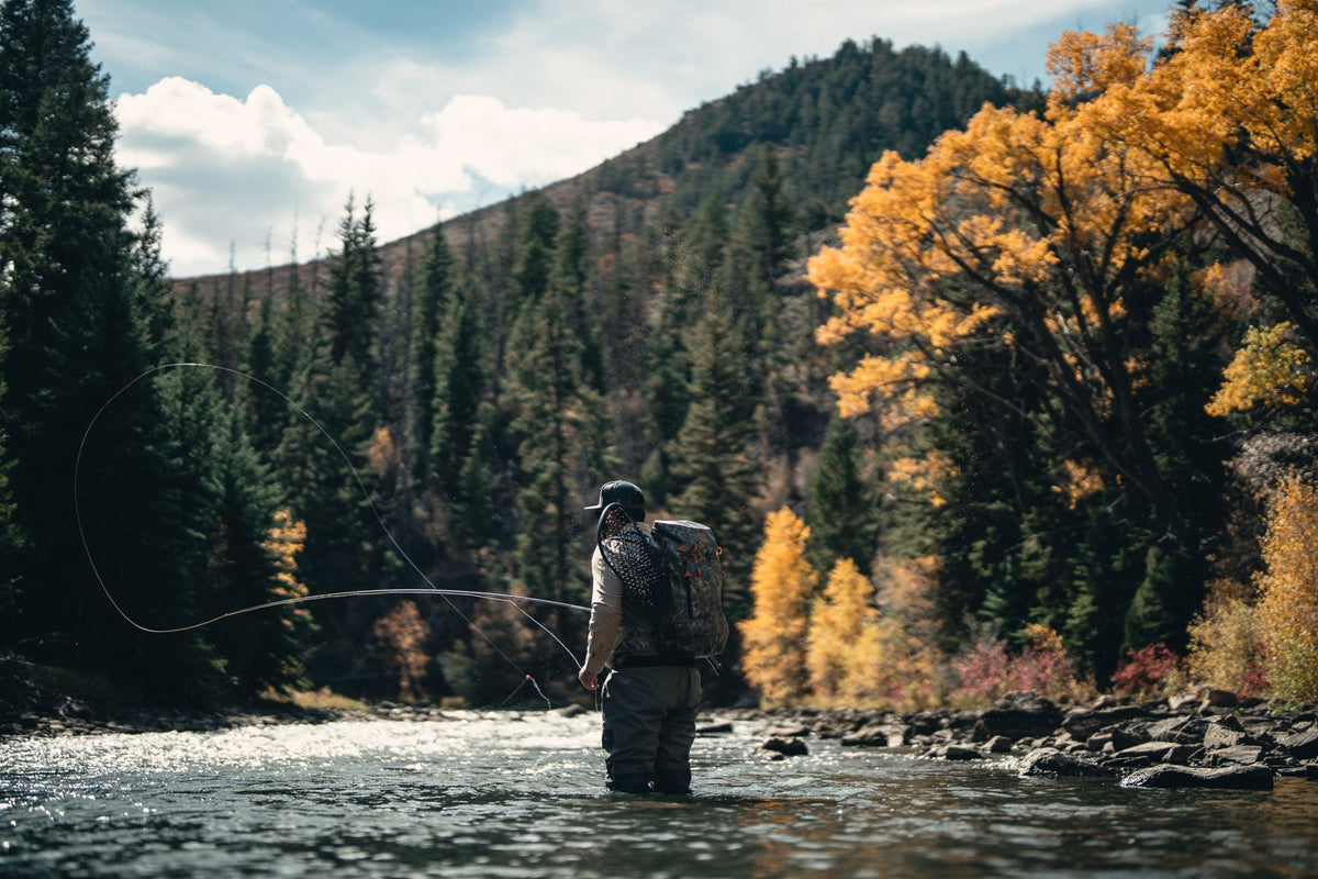 Fishpond Thunderhead HD Backpack, angler casting in a river