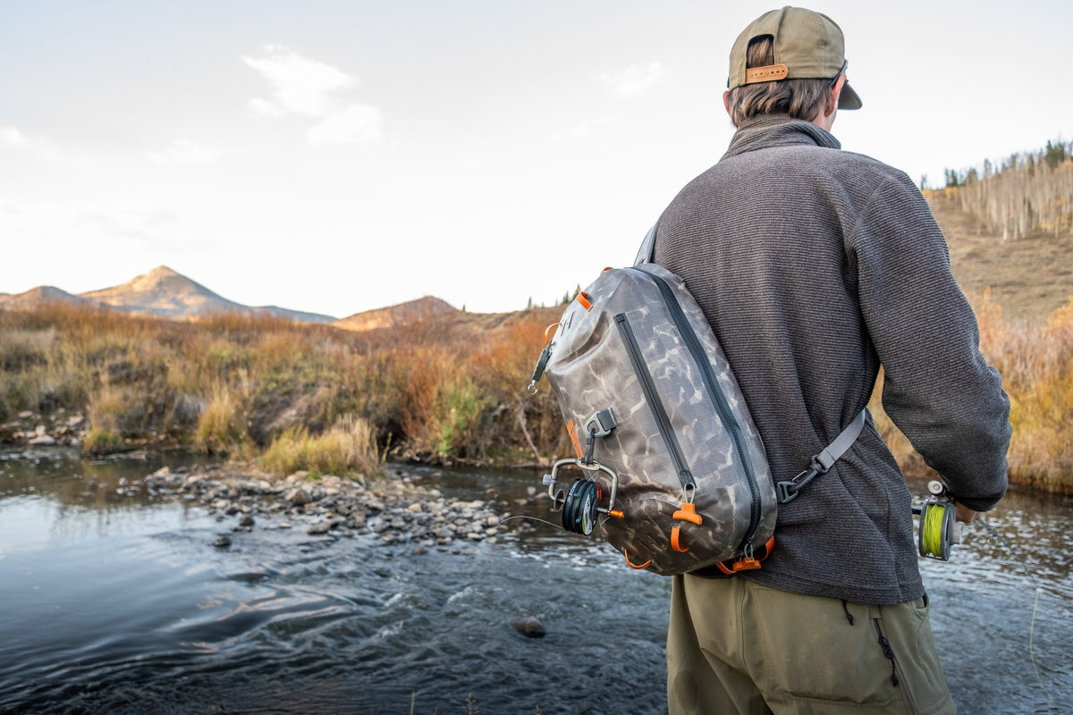 Fishpond Thunderhead HD Sling, Shadowcast Camo, worn by angler on a river