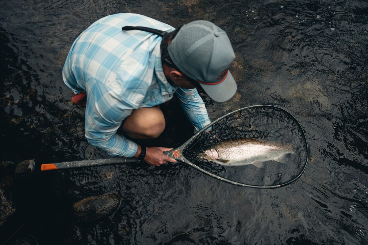 Fishpond Nomad Boat Net - Shadowcast Camo - 2.0, angler kneeling with trout in net