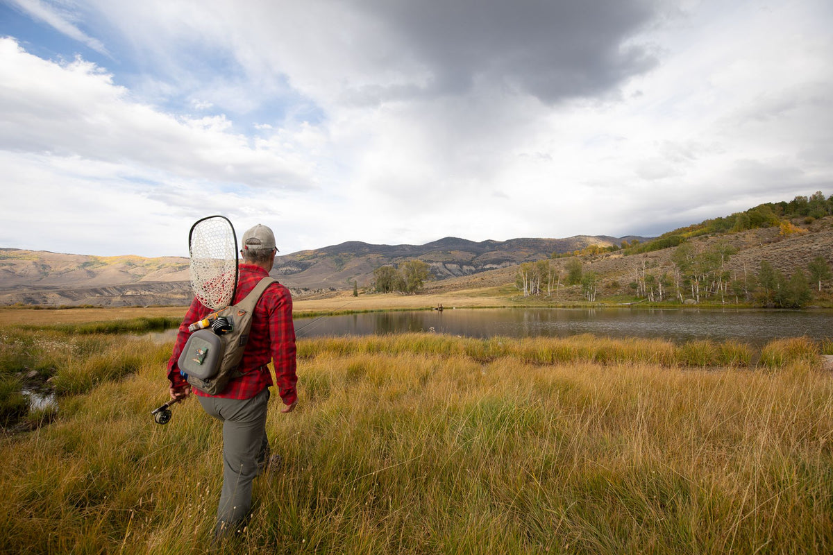 Guy Walking To A Pond Wearing Fishpond summit sling