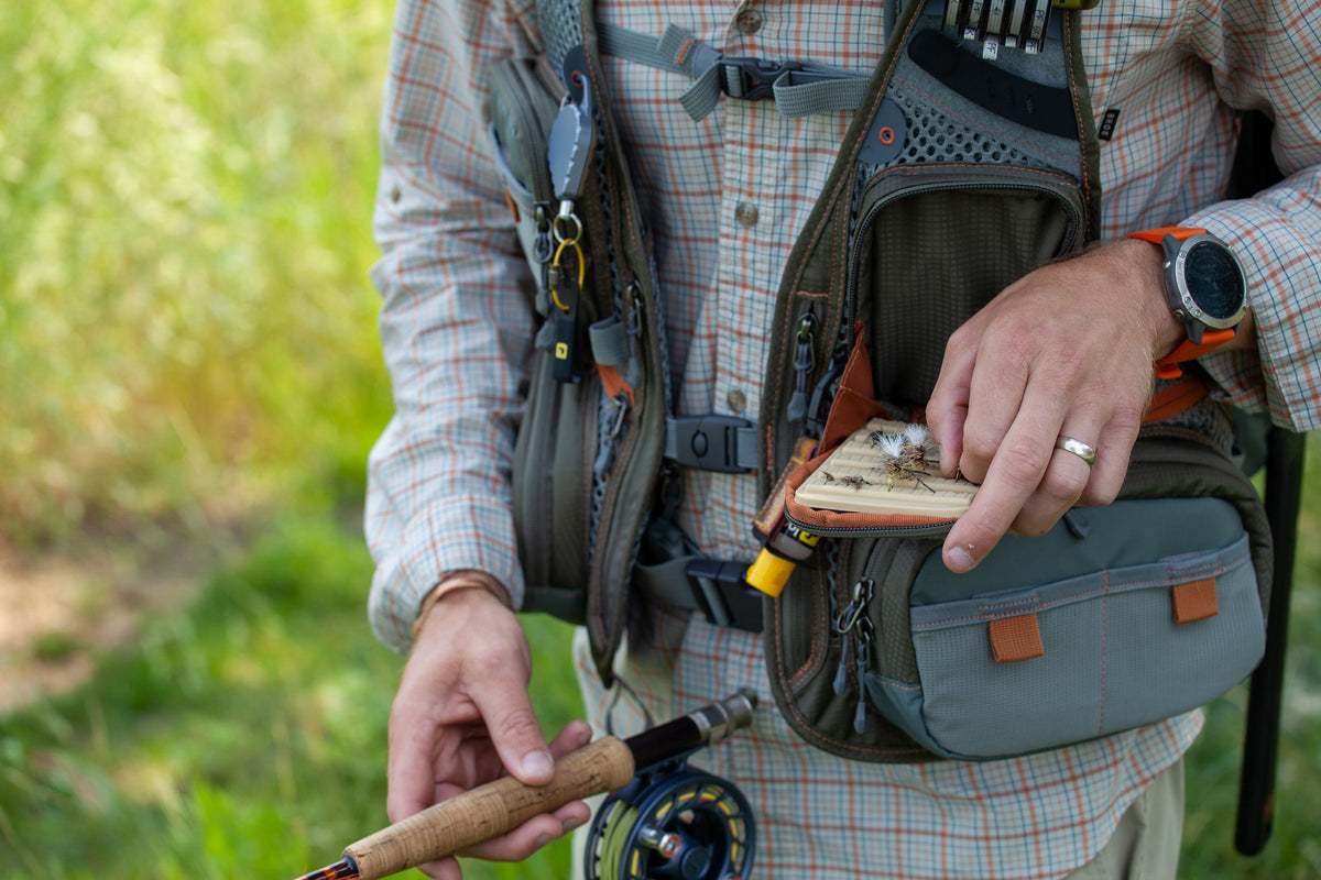 Guy Getting a fly from front pocket of Fishpond Sagebrush Pro Mesh Vest